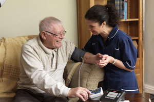 Nurse Taking Senior Man's Blood Pressure.