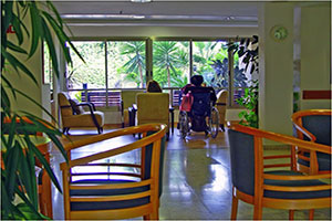 Two Seniors Sitting And Looking Out The The Window In A Retirement Home.