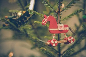 Red Wooden Horse Ornament On Christmas Tree.