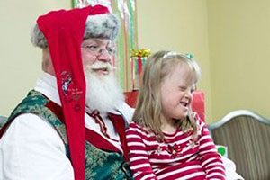 Santa Clause With A Little Girl Sitting On His Lap.