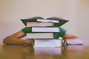 Stressed Student Behind A Stack Of Books.