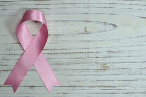 Breast Cancer Awareness Pink Ribbon On A Wooden Table.