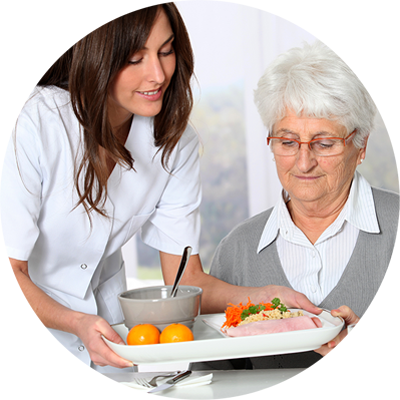 Home Support Worker serving meal to senior woman.