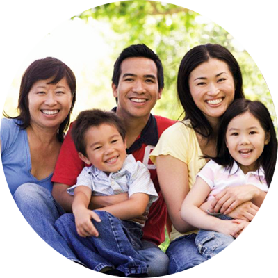 Photo of family (parents, children and aunt) smiling.