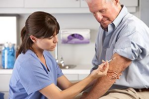 Nurse Giving Flu Shot To Man.